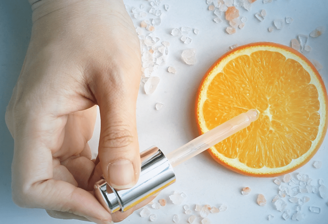 Image-displays-hand-with-pipette-placed-on-orange-slice